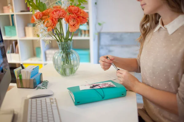 Gros plan d'une femme mains signer la carte postale à la main dans le bureau — Photo