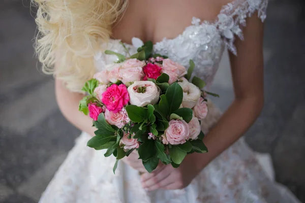 Bouquet de fiancées. Belle fille dans une robe de mariée luxueuse tenant des fleurs — Photo