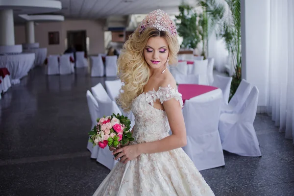 Ung mode bruden med perfekt hud och make up, lockigt hår, blommor och tiara på huvudet, inomhus — Stockfoto