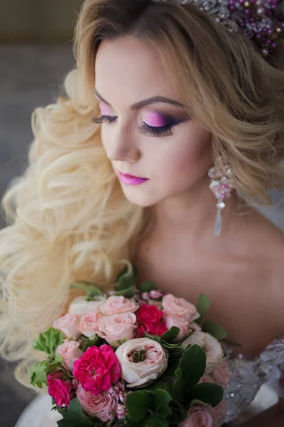 Ung mode bruden med perfekt hud och make up, lockigt hår, blommor och tiara på huvudet, mot ett fönster inomhus — Stockfoto