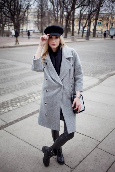 年轻、 髋关节和吸引人的金发女郎在城里，走在时尚的帽子和一件灰色的大衣的女孩 — 图库照片