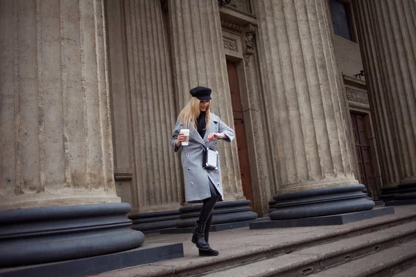 Unga, trendiga och attraktiva blondin som promenerar runt i staden med kaffe för att gå, ser på klockan och skyndar på business — Stockfoto