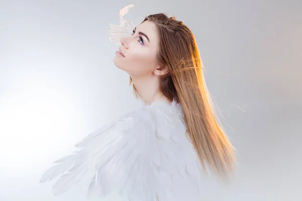 Junges, wunderschönes blondes Mädchen im Bild eines Engels mit weißen Flügeln. — Stockfoto