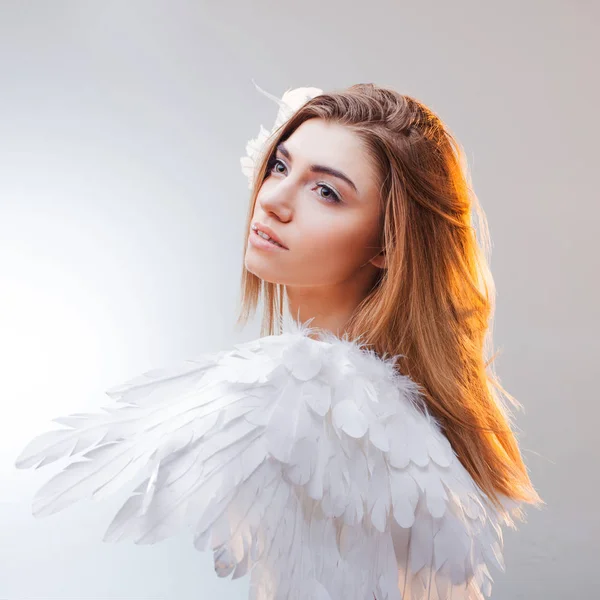 Young, wonderful blonde girl in the image of an angel with white wings. — Stock Photo, Image