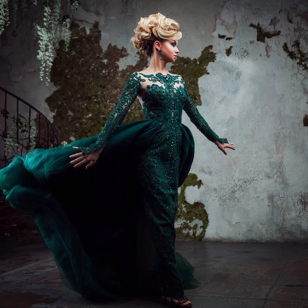 Portrait de jeune femme blonde séduisante dans une belle robe verte. Fond texturé, intérieur. Coiffure de luxe — Photo