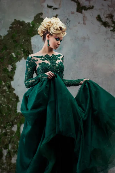 Portré, fiatal vonzó szőke nő, egy gyönyörű zöld ruhát. Textúrázott háttérre, belső. Luxus frizura — Stock Fotó