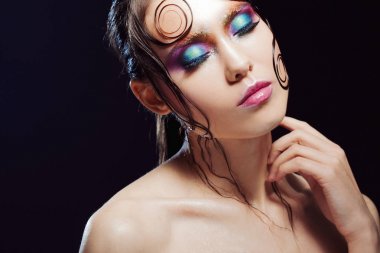 Genç güzel kız parlak makyaj ile ıslak göz Parlatıcı, koyu arka plan