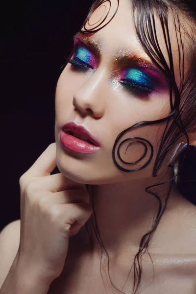 Молодая красивая девушка яркий макияж с влажным взглядом блеск, темный фон — стоковое фото