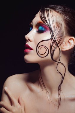 Genç güzel kız parlak makyaj ile ıslak göz Parlatıcı, koyu arka plan