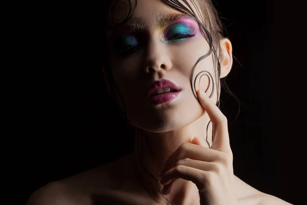 Krásná mladá dívka světlý make-up s mokrou vypadat lesk, tmavé pozadí, tmavé záhadné siluetu ve stínu — Stock fotografie