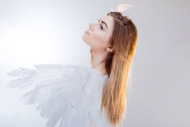 Beyaz kanatlı bir melek görüntüsündeki genç, harika sarışın kız.