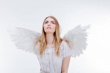 Gökten bir melek. Beyaz kanatlı bir melek görüntüsündeki genç, harika sarışın kız.
