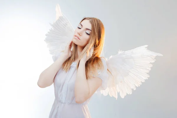Gökten bir melek. Beyaz kanatlı bir melek görüntüsündeki genç, harika sarışın kız. — Stok fotoğraf