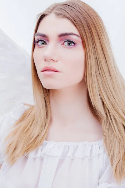 Um anjo do céu. Jovem, menina loira maravilhosa na imagem de um anjo com asas brancas. Retrato close-up — Fotografia de Stock