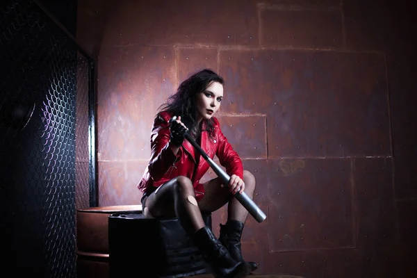 Aggressive punk woman with a bat, in red leather jacket — Stock Photo, Image