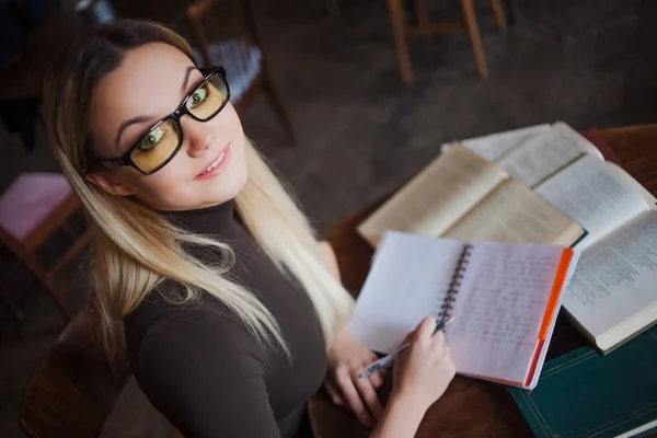 Fiatal nő diák az Egyetem. Felkészülés a vizsgára, és a tanulságok a nyilvános könyvtár. — Stock Fotó