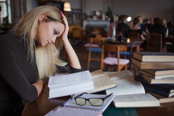 Tired young woman student of the University. Preparing exam and learning lessons in public library. — Stock Photo, Image