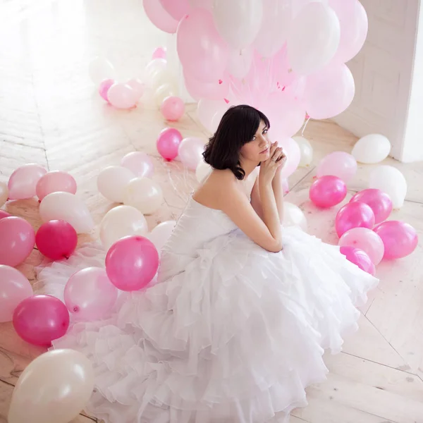 Young woman in wedding dress in luxury interior with a mass of pink and white balloons. — Stock Photo, Image