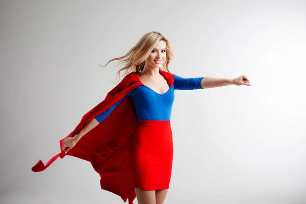 Superhero Woman. Young and beautiful blonde in image of superheroine in red Cape growing — Stock Photo, Image