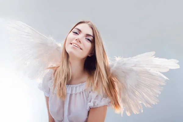 Um anjo do céu. Jovem, menina loira maravilhosa na imagem de um anjo com asas brancas . — Fotografia de Stock
