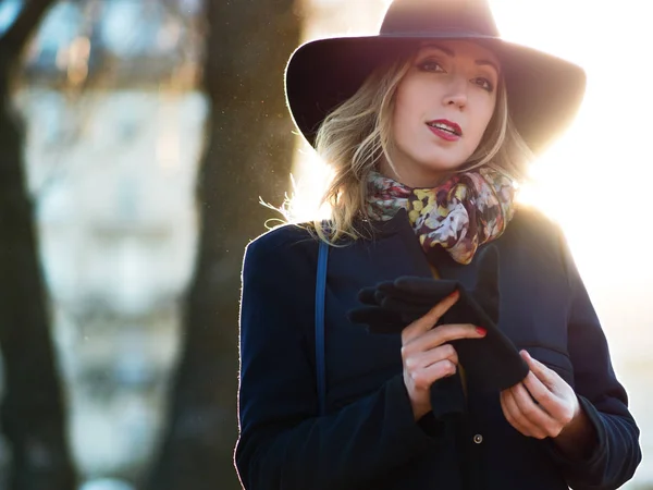 歩いてエレガントな帽子とスカーフ、若い女性。路上で魅力的なブロンドの肖像画. — ストック写真