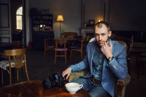 El joven se sienta y disfruta del café por la mañana. Retrato en el interior — Foto de Stock