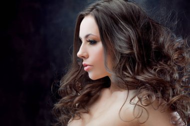 Güzel esmer kız lüks kıvırcık saçlı. Stüdyo portre koyu arka plan arka plan üzerinde. Mükemmel saç