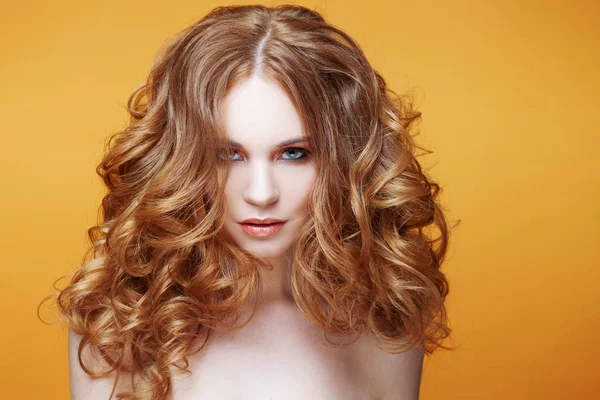 Hermosa chica pelirroja con pelo rizado de lujo. Retrato de estudio sobre fondo amarillo. Cabello excelente — Foto de Stock