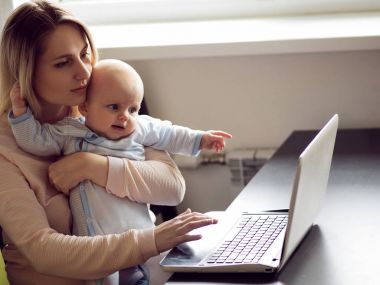 Genç anne ev ofiste bilgisayar ve bebeği. Serbest meslek ya da blogger, iş ve çocuk bakımı.