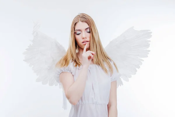 O Angel guarda o segredo. Jovem, menina loira maravilhosa na imagem de um anjo com asas brancas . — Fotografia de Stock