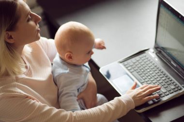 Genç anne ev ofiste bilgisayar ve bebeği. Serbest meslek ya da blogger, iş ve çocuk bakımı.
