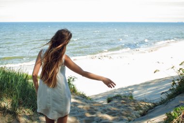 Deniz kıyısında genç sevimli esmer kadın. Doğa kucaklayan Kollarını açarak