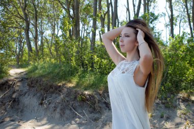 Deniz kıyısında genç sevimli esmer kadın. Mutlu tatiller, orman deniz kenarında