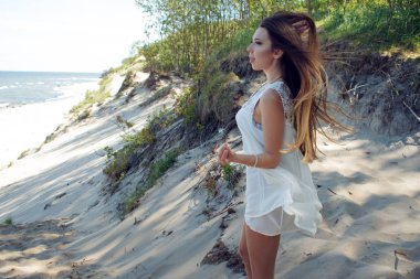 Deniz kıyısında genç sevimli esmer kadın. Mutlu tatiller, orman deniz kenarında