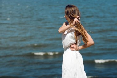 Deniz kıyısında genç sevimli esmer kadın. Üstten Görünüm şaşırtıcı. Açık gökyüzü karşı genç kadın portresi