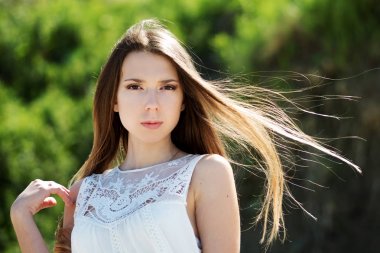 Genç sevimli esmer kadın. Portre portre açık havada yeşil yeşillik bir arka plan üzerinde.