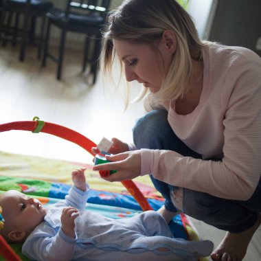 Birlikte oynayan genç anne ve çocuk çocuk kapalı yerde. Yumuşak görüntü