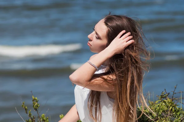 Junge charmante brünette Frau an der Küste. Tolle Aussicht von oben. Porträt einer jungen Frau bei klarem Himmel — Stockfoto