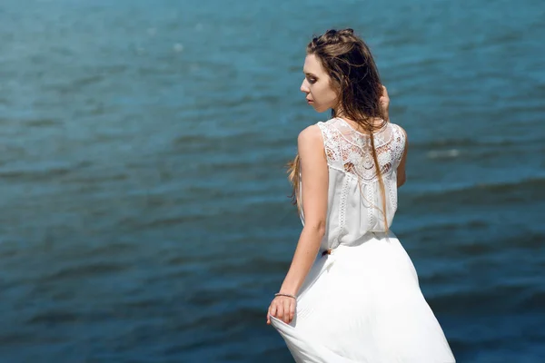 Young charming brunette woman on sea coast. Amazing view from the top. Portrait of young woman against clear sky — Stock Photo, Image