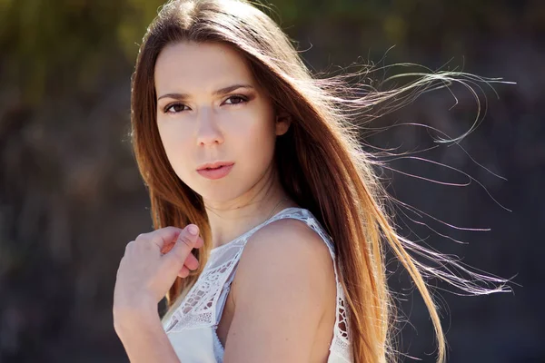 Jovem mulher morena encantadora. Retrato de close-up ao ar livre em um fundo de folhagem verde . — Fotografia de Stock