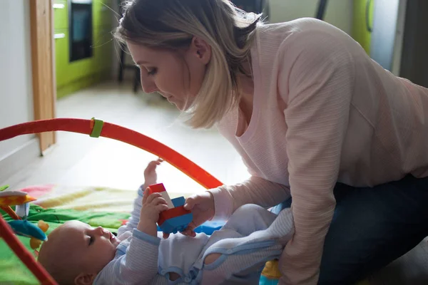 Young mother and child boy playing together indoor, on the floor. Soft image — Stock Photo, Image