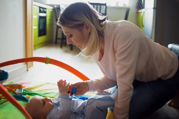 Young mother and child boy playing together indoor, on the floor. Soft image — Stock Photo, Image