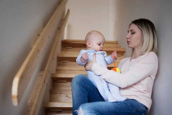 Fiatal anya és a gyermek ült a lépcsőn, ház. Boldog család — Stock Fotó