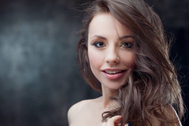 Güzel esmer kız lüks kıvırcık saçlı. Stüdyo portre karanlık bir arka plan üzerinde. Mükemmel saç