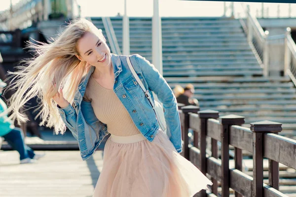 Jeune fille joyeuse sur le bord de la mer. Jeune promenade blonde sur la promenade . — Photo