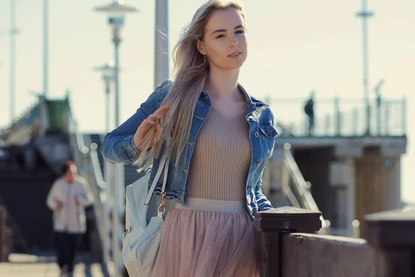 Giovane ragazza allegra sulla riva del mare. Giovane donna bionda sorridente. Stile alla moda — Foto Stock