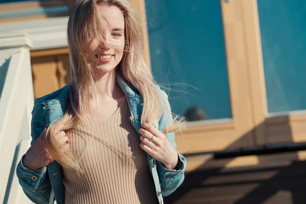Молода весела дівчина. Молода блондинка посміхається в джинсовій куртці — стокове фото
