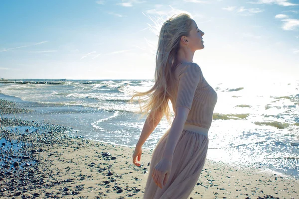 Glad flicka på stranden. Unga blonda kvinnan leende. Öppna armar kramar havet — Stockfoto