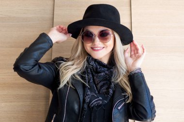 Komik ve güzel sarışın güneş gözlüğü ve şapka. Trendy kız portre açık. Gülüyor ve şapka tutan