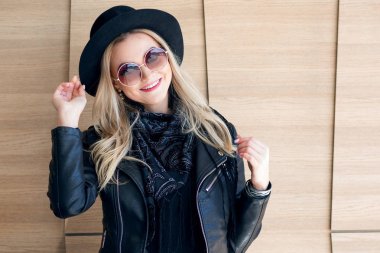 Komik ve güzel sarışın güneş gözlüğü ve şapka. Trendy kız portre açık. Gülüyor ve şapka tutan